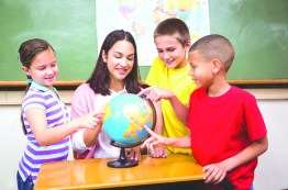 stock-photo-students-pointing-to-places-on-a-globe-at-the-elementary-school-309239480